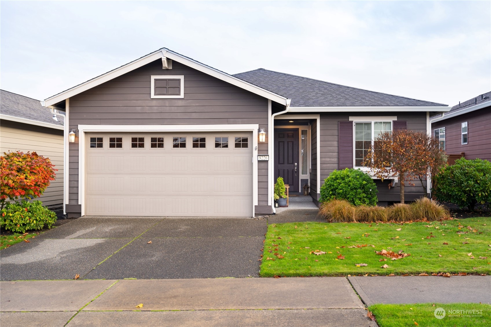 a front view of a house with a yard and potted plants