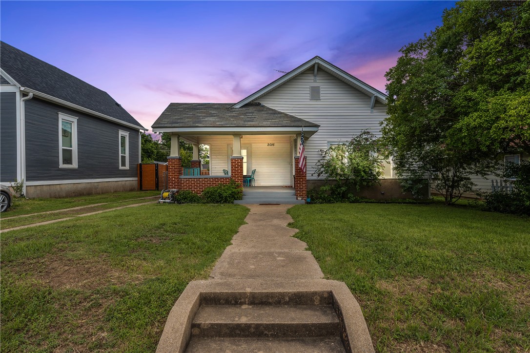 a front view of a house with a yard and garden