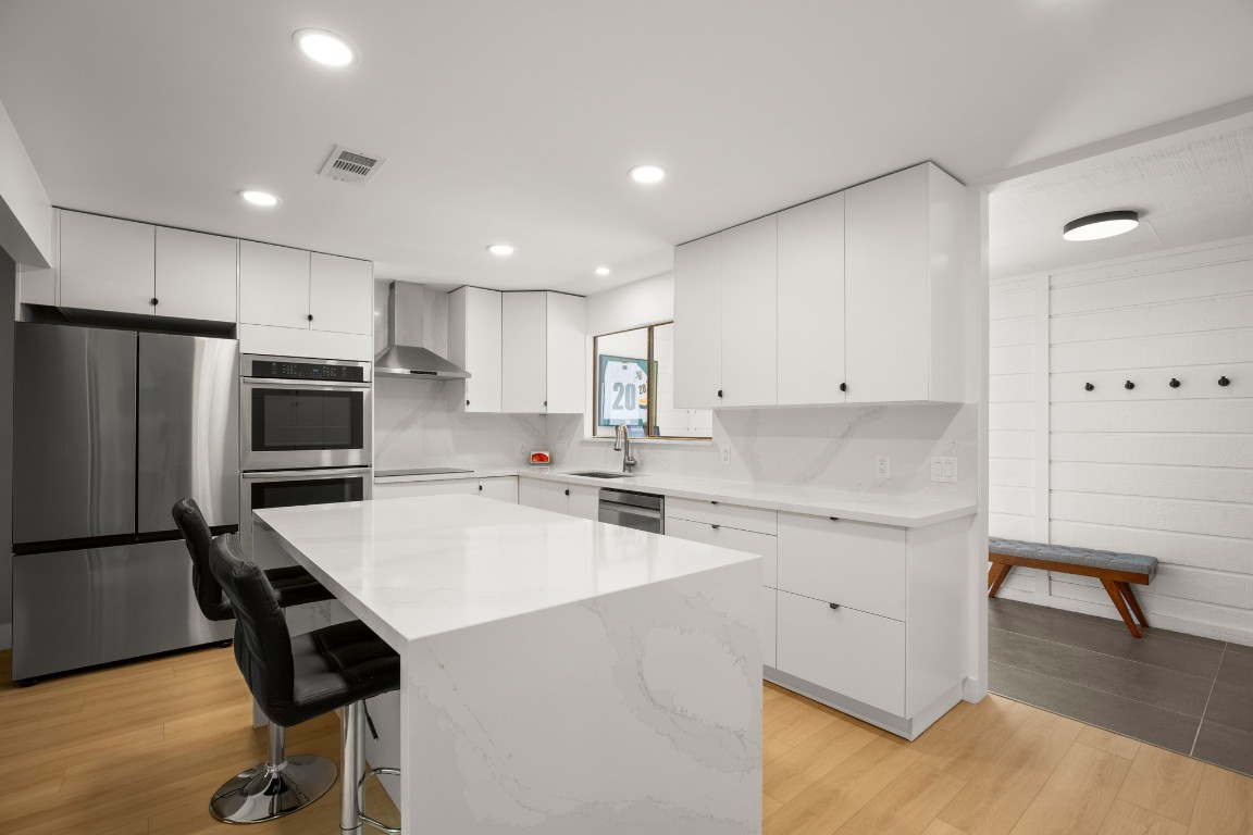 a kitchen with a sink a counter top space stainless steel appliances and cabinets