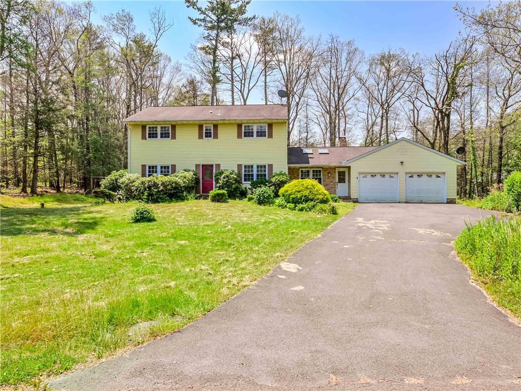 a view of a house with a big yard and large trees