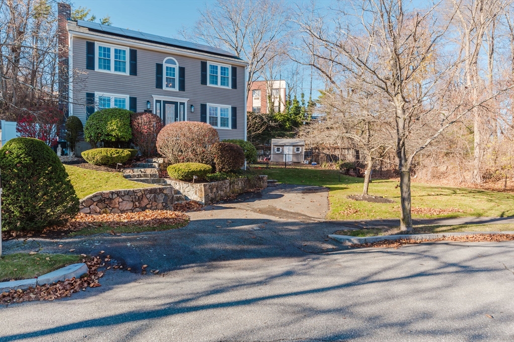 a front view of a house with yard and lake view