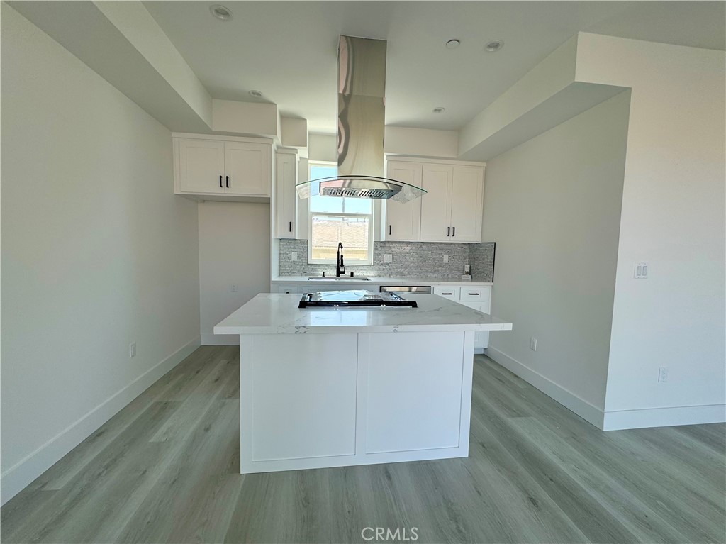 a kitchen with kitchen island a sink stove and wooden floor