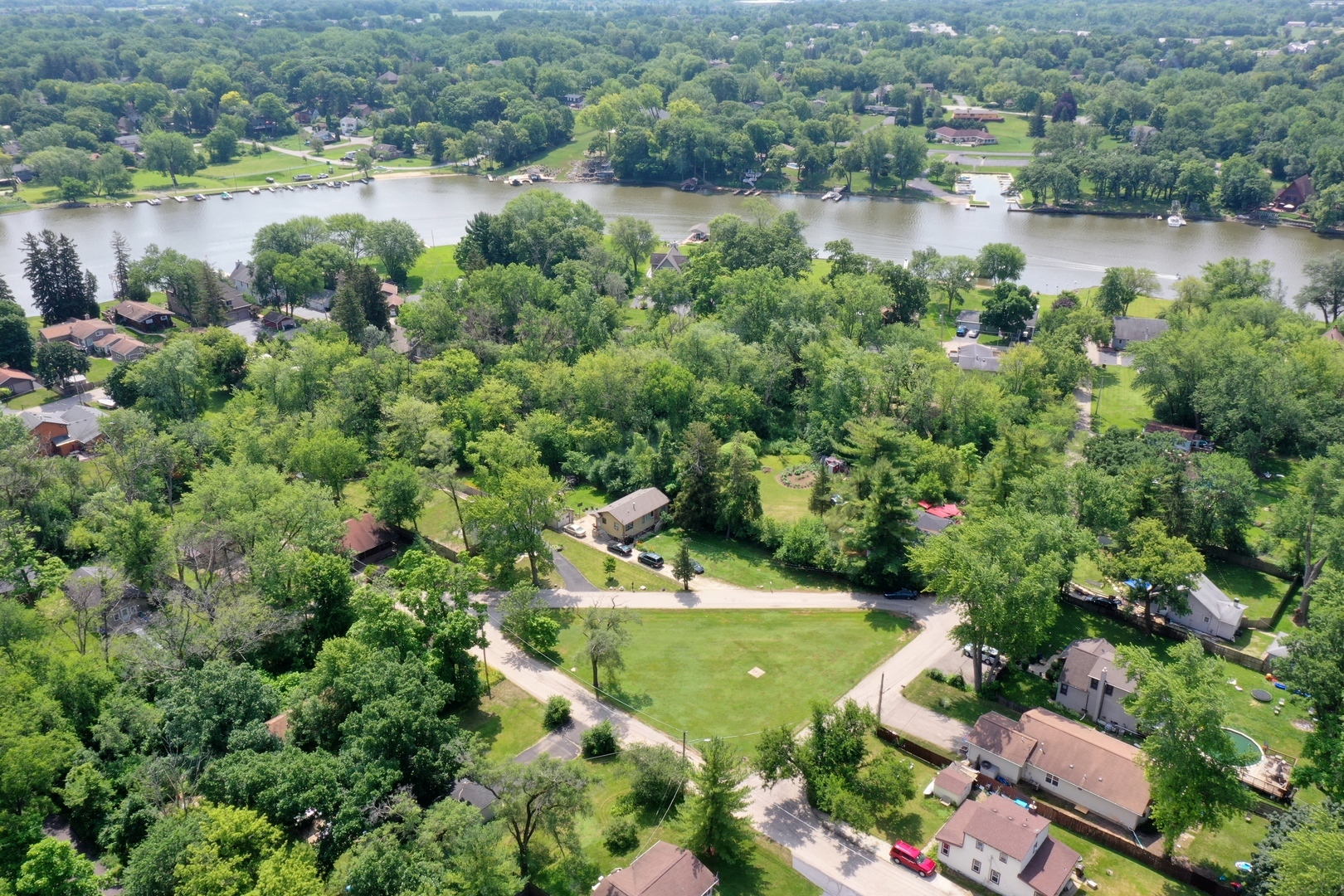 a view of a lake with a yard and large trees