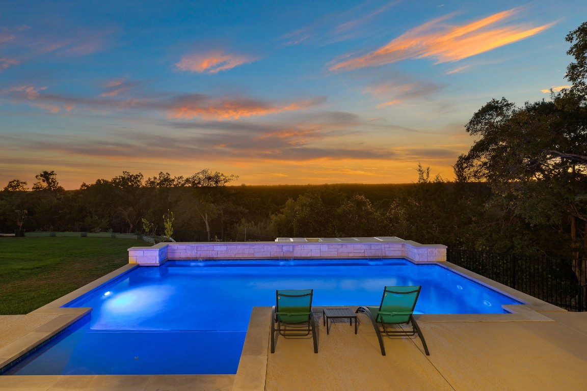 a view of swimming pool with furniture and a yard