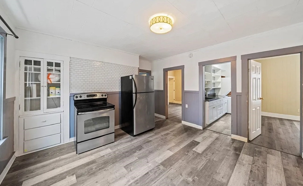 a kitchen with granite countertop a refrigerator and a stove top oven