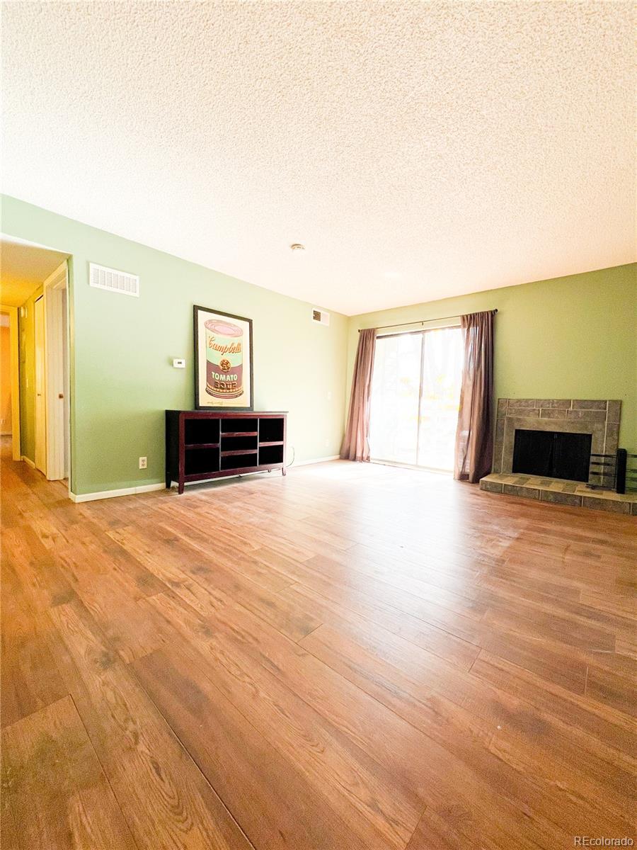 a view of a livingroom with wooden floor and furniture