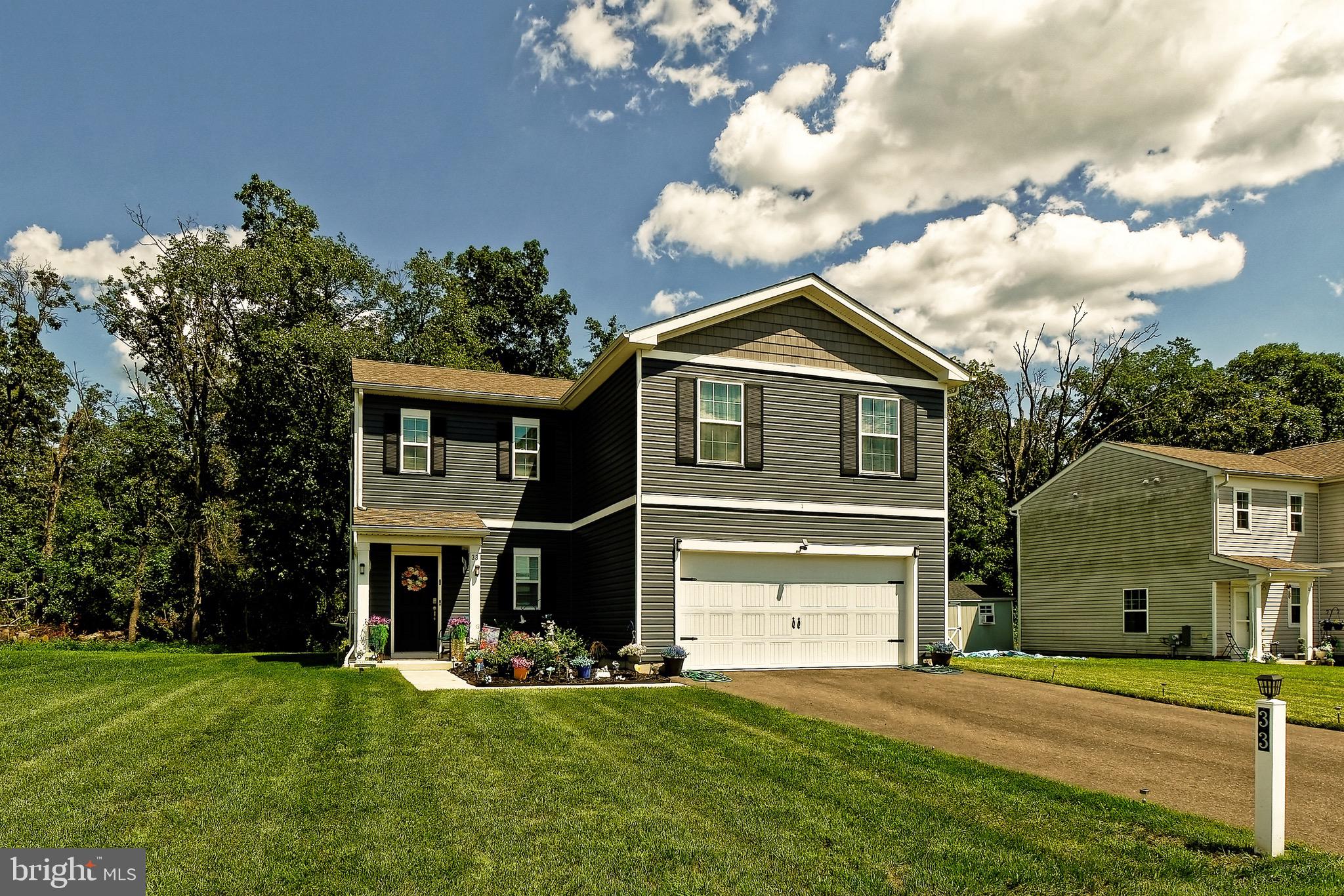 a front view of a house with a garden and yard