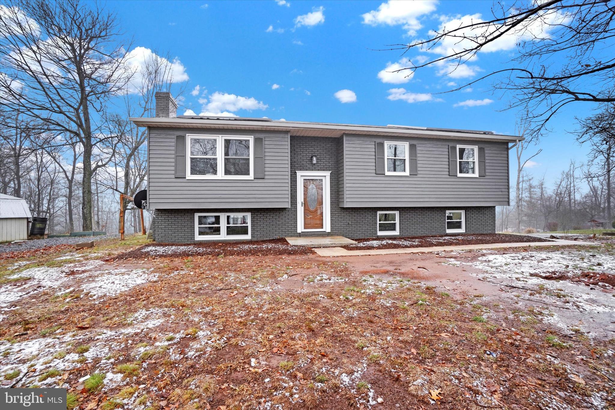 a front view of a house with yard and parking