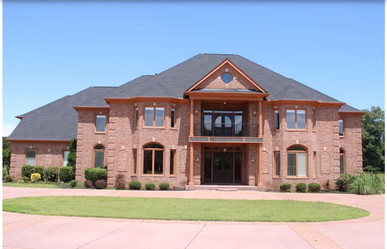 View of front of home featuring a front yard and a balcony