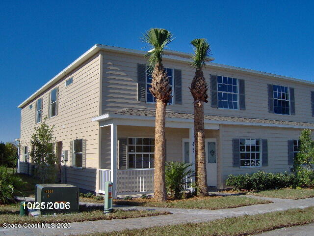 a view of a house with a yard and a tree