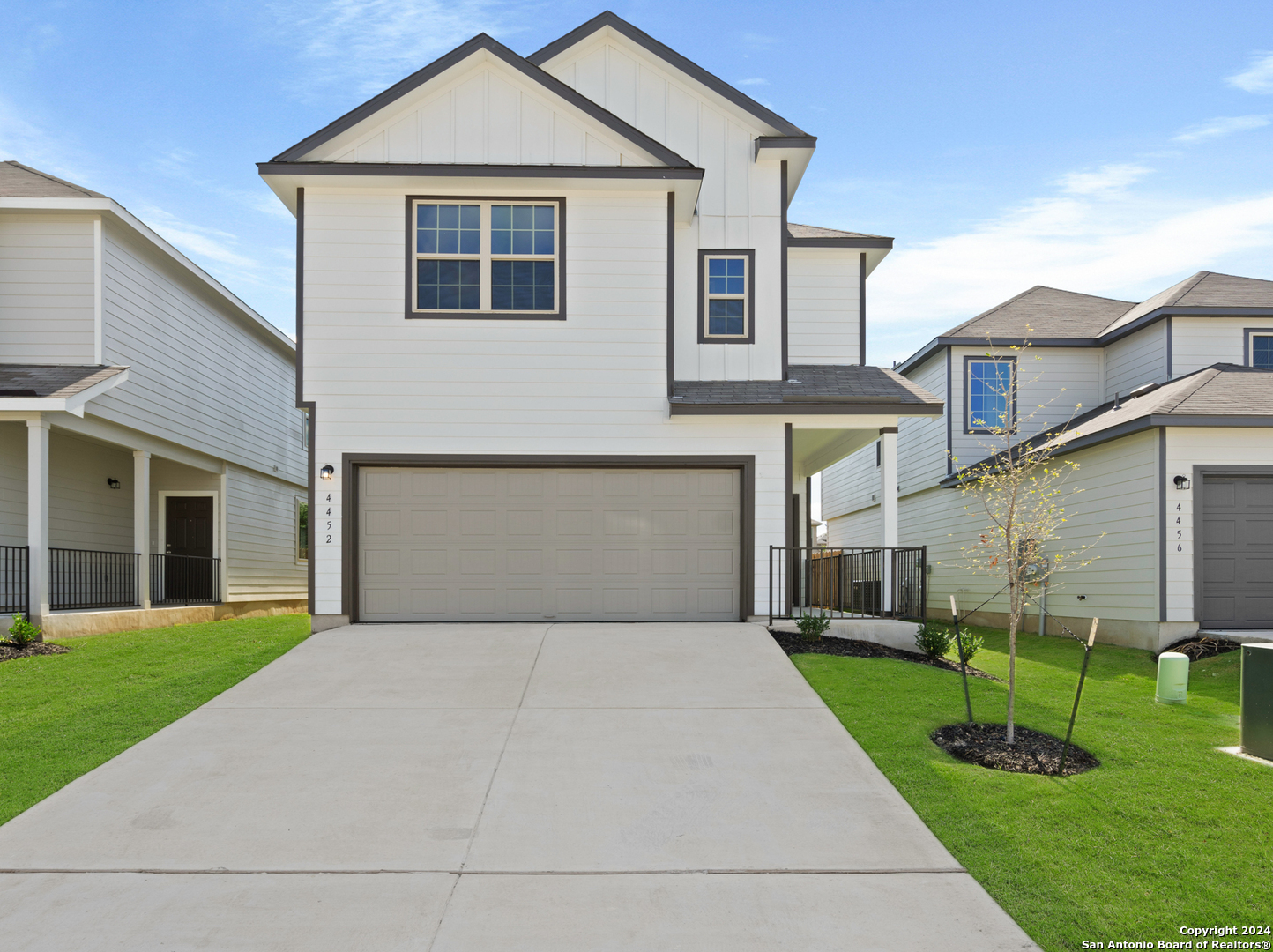 a front view of a house with a yard and trees