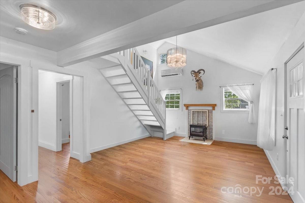 a view of an empty room with stairs and a fireplace