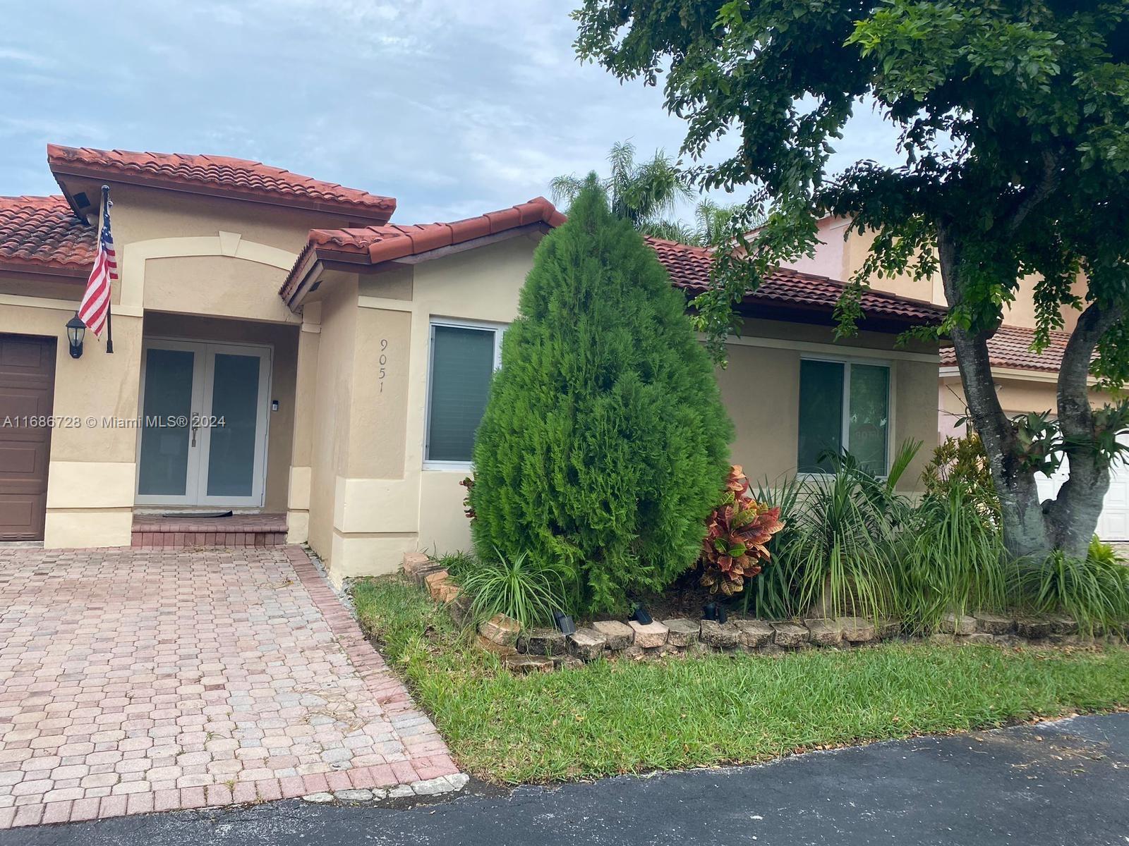 a house that has a tree in front of the house