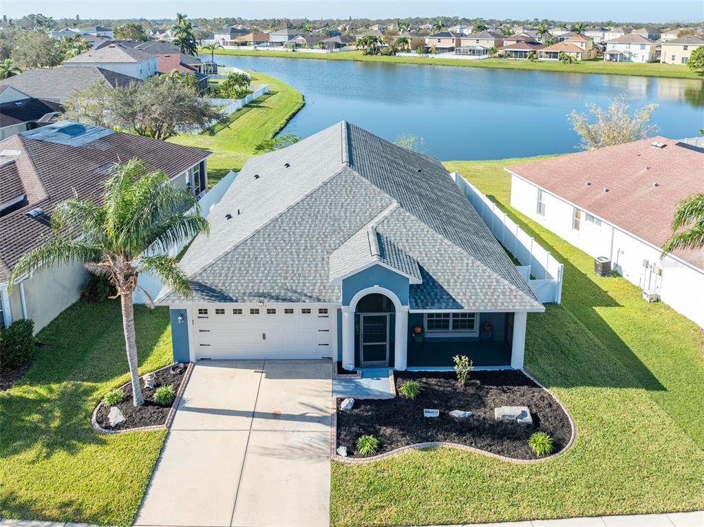 an aerial view of a house with a yard and lake view