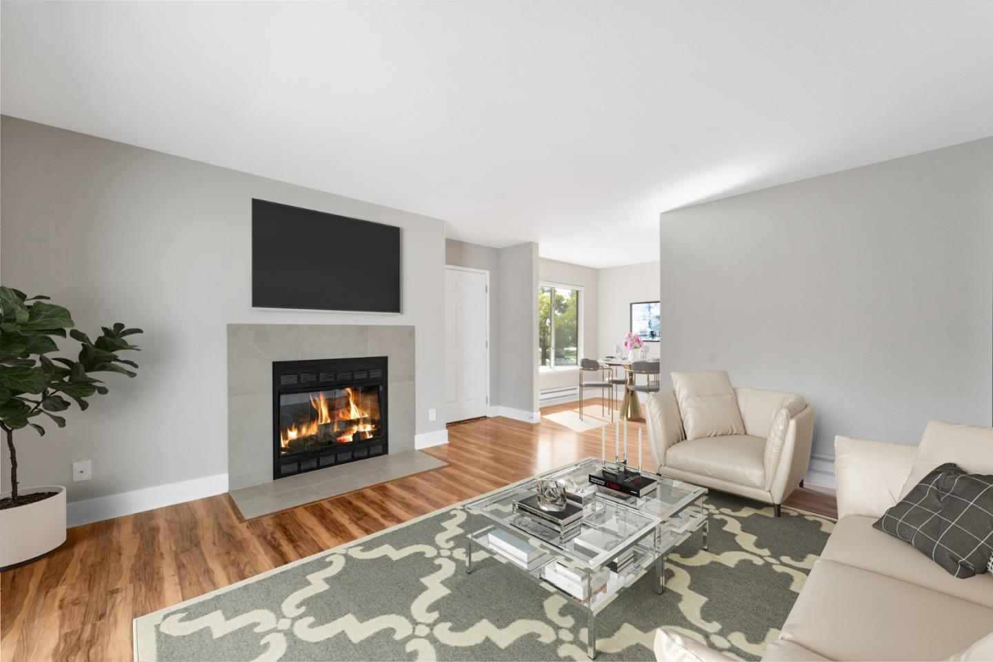 a living room with furniture a fireplace and a potted plant