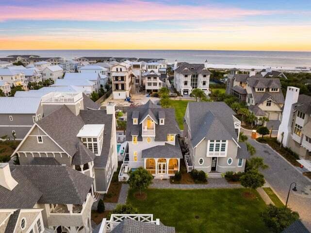 an aerial view of residential houses with outdoor space and ocean view