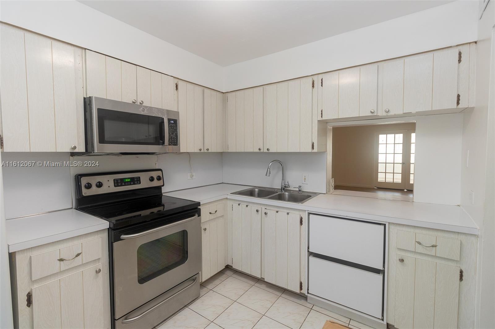 a kitchen with granite countertop white cabinets white stainless steel appliances and a sink