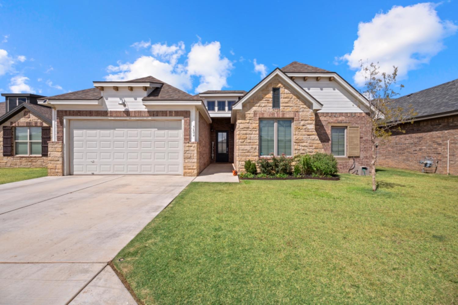 a front view of a house with a yard and garage