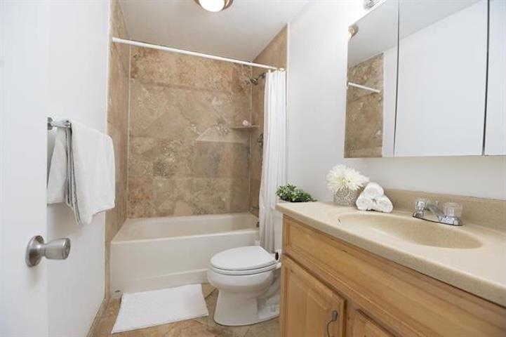 a bathroom with a granite countertop sink toilet and shower