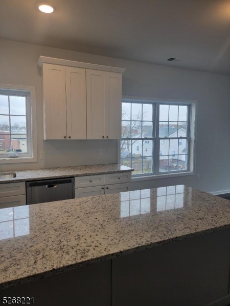 a kitchen with granite countertop a stove a sink and a microwave