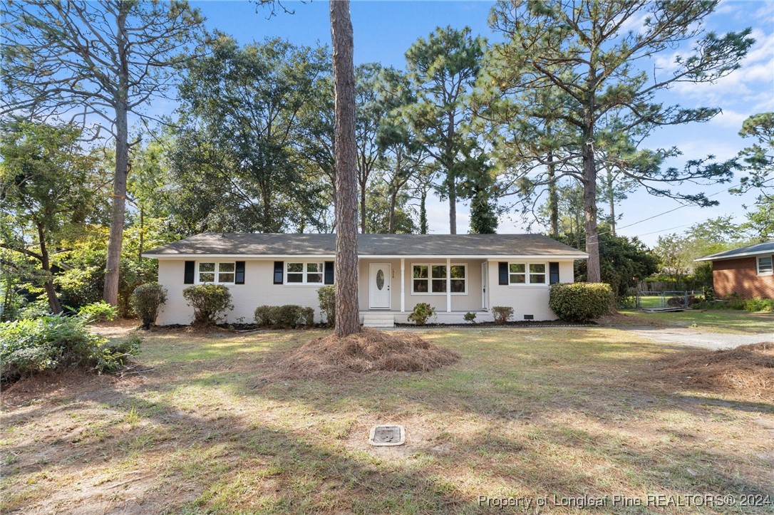 a view of a house with a big yard and large trees