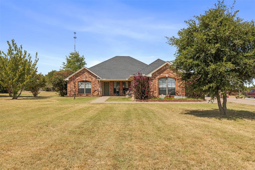 a front view of house with yard and trees