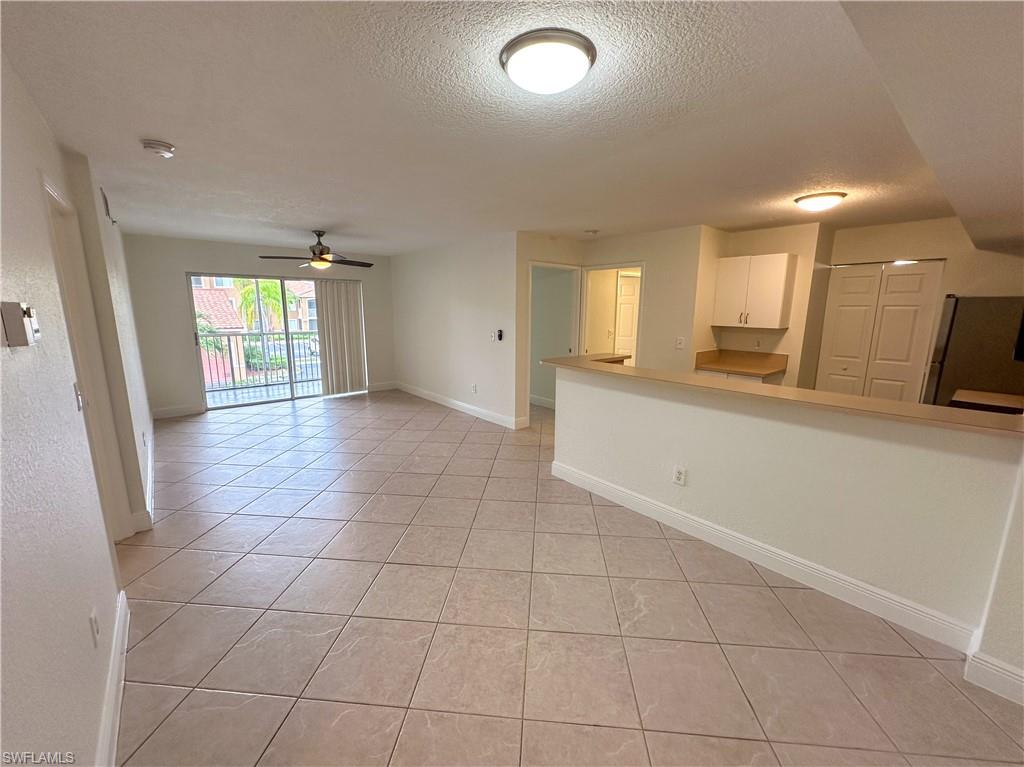 a view of a hallway with wooden floor and a kitchen