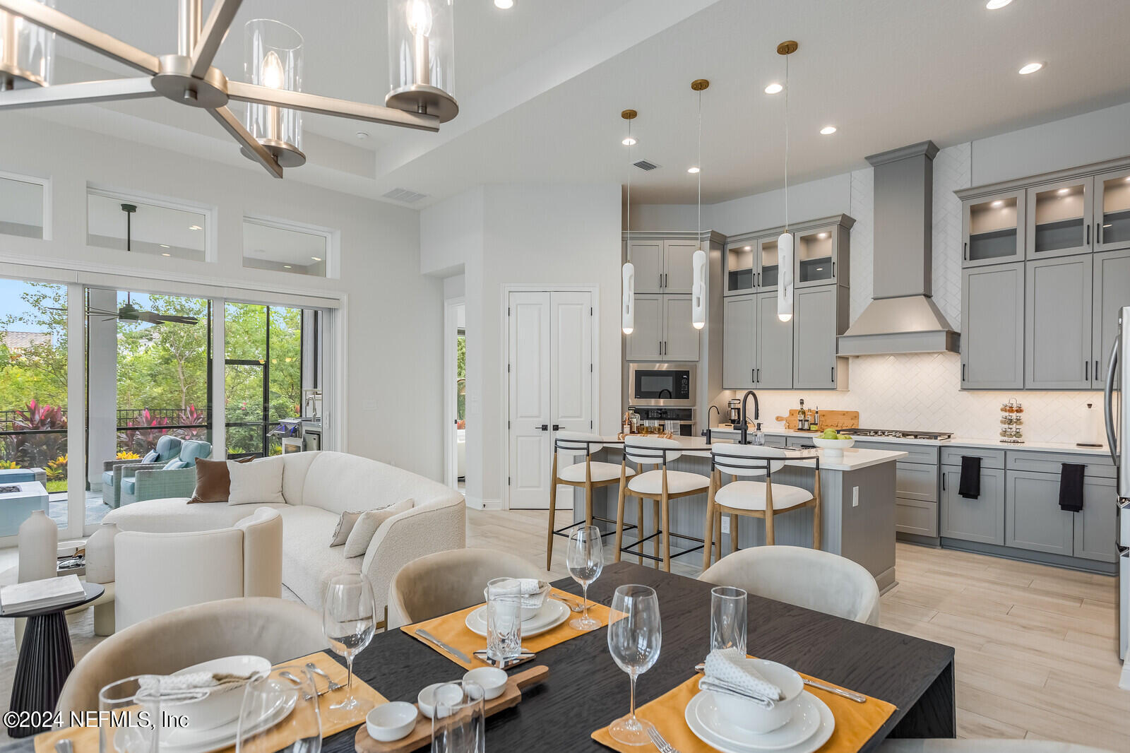 a living room with furniture kitchen view and a large window