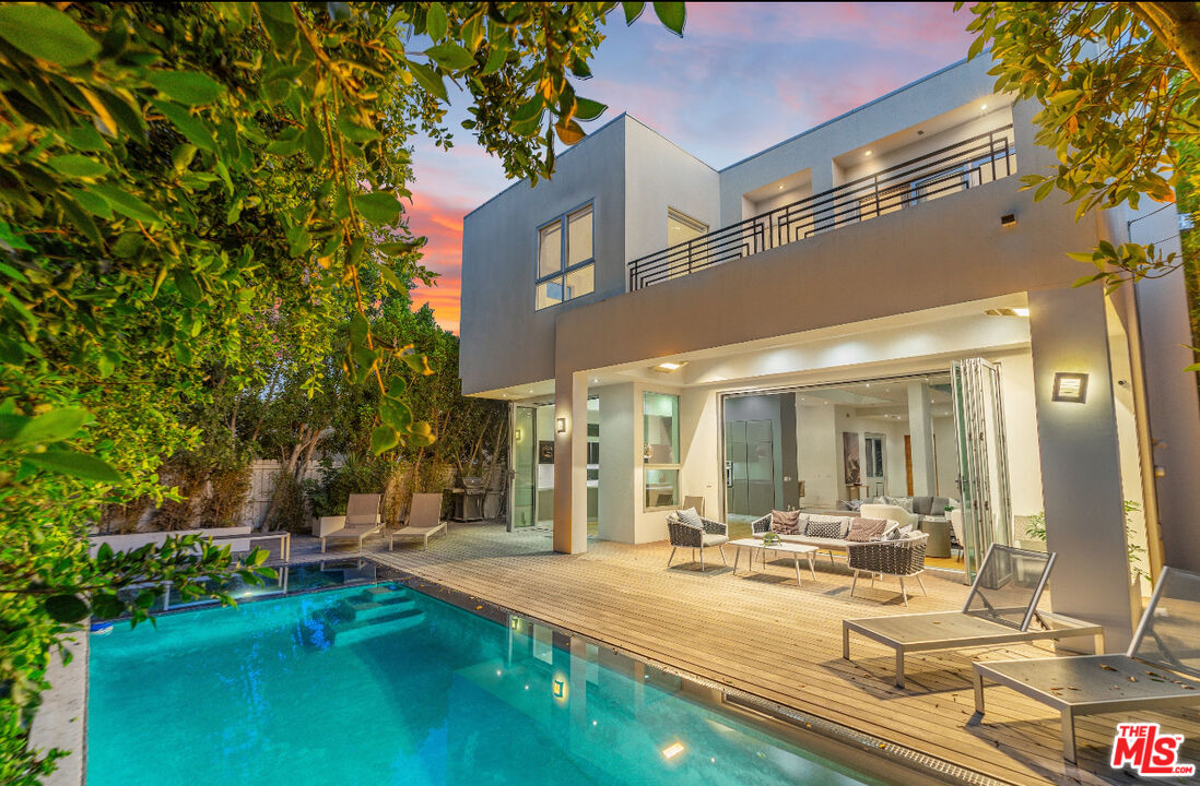 a view of a house with swimming pool and sitting area