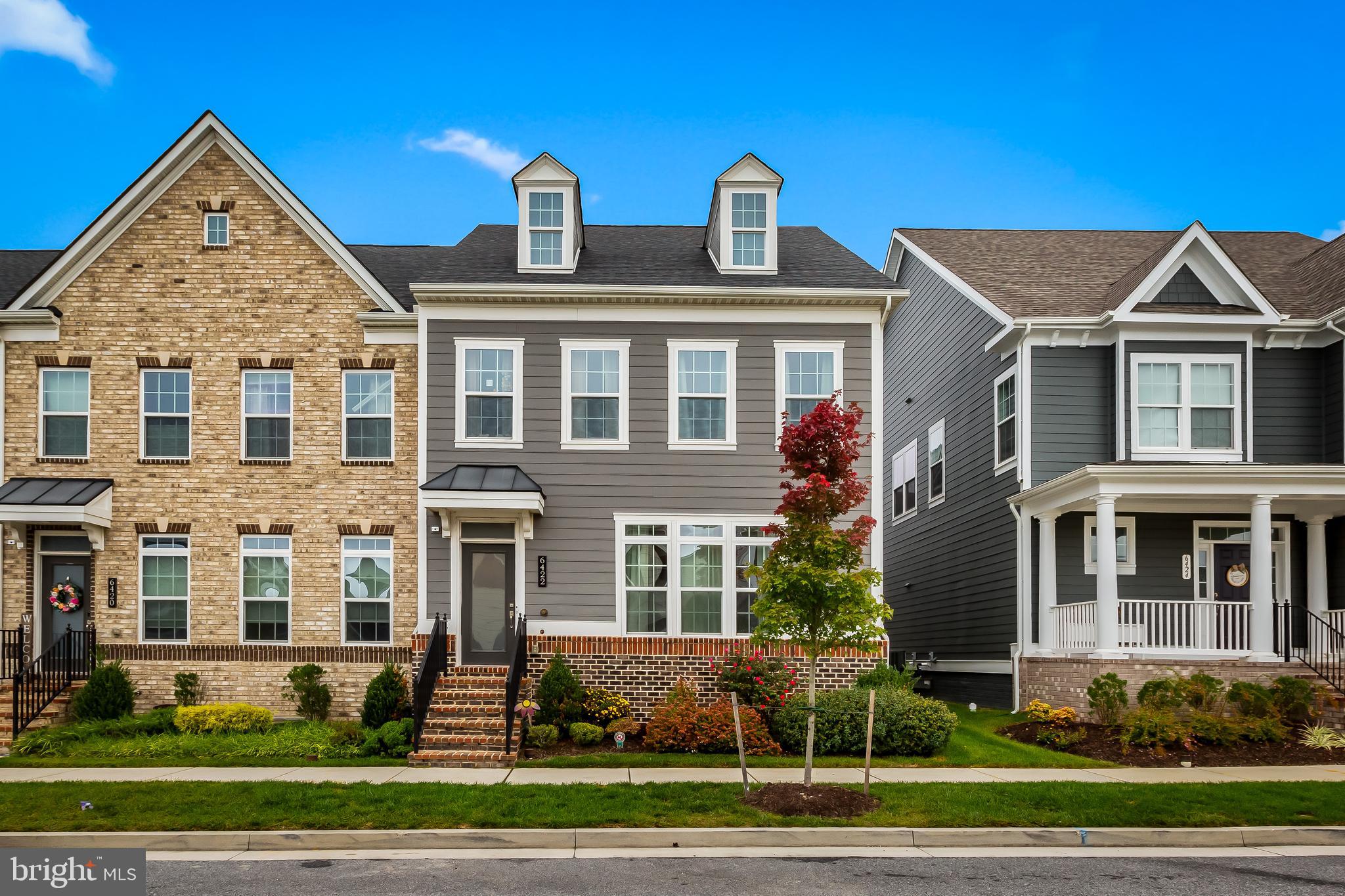 a front view of a residential apartment building with a yard