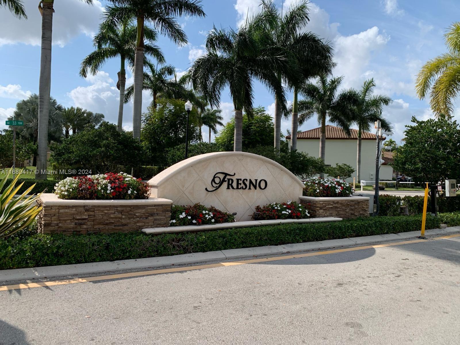 a view of a park that has a street sign and a parked car