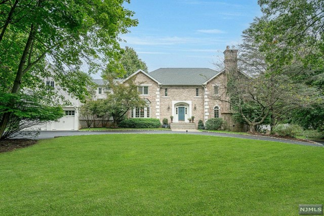 a view of a big house with a big yard and large trees