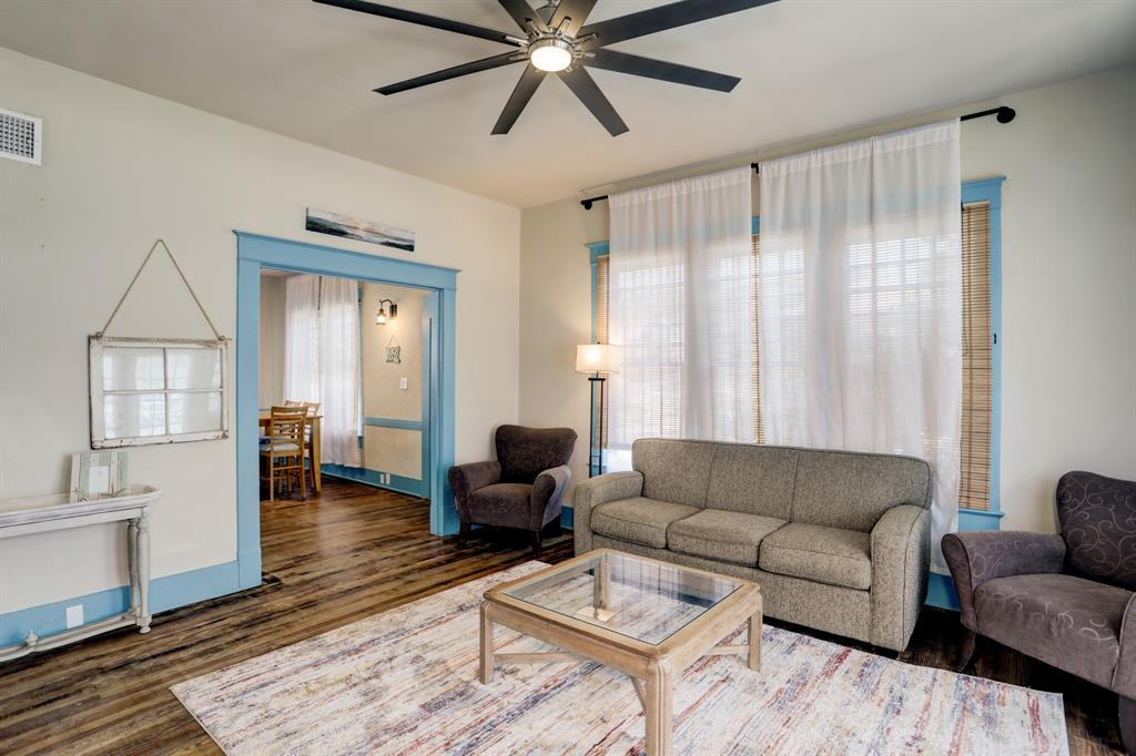 a living room with furniture and a wooden floor