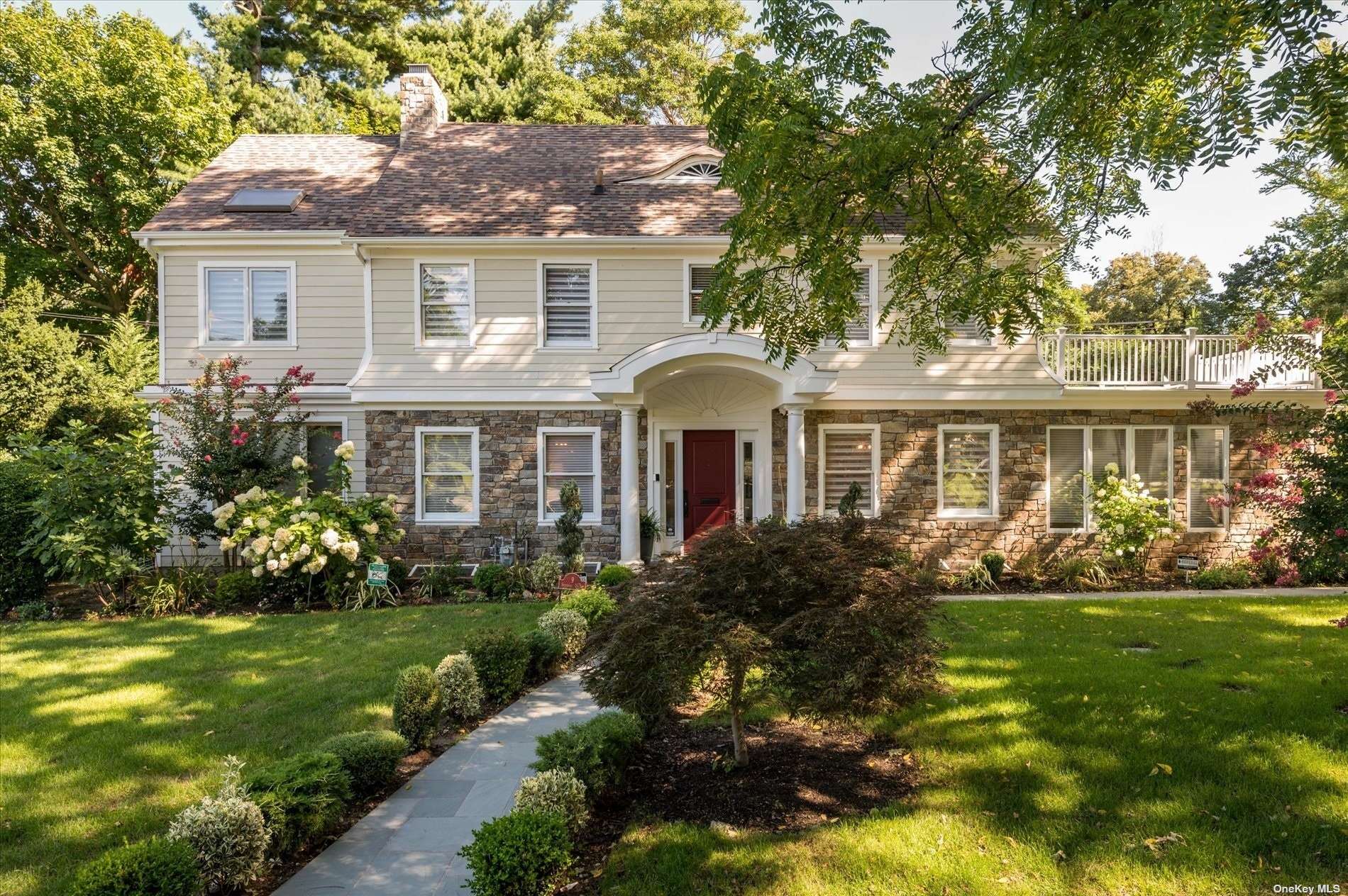 a front view of a house with a yard and potted plants