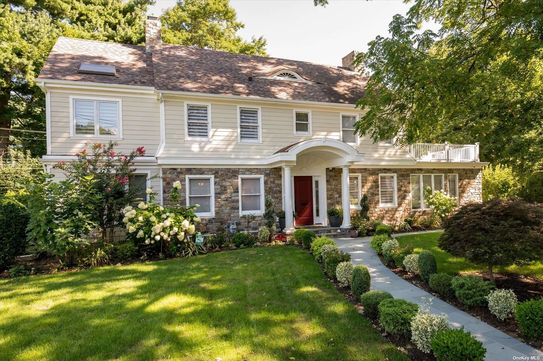 a front view of a house with a yard and potted plants