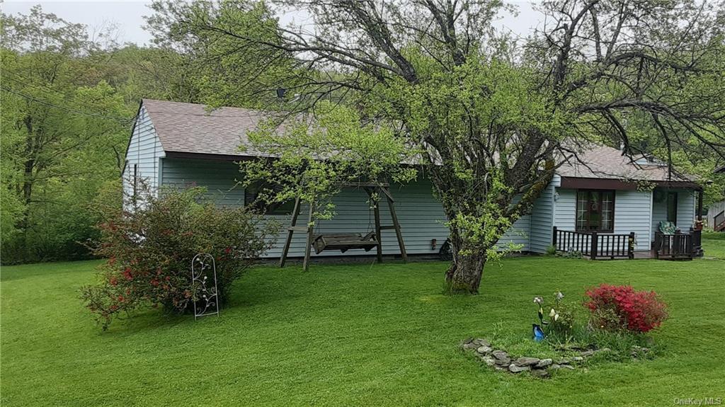 a backyard of a house with potted plants and large tree