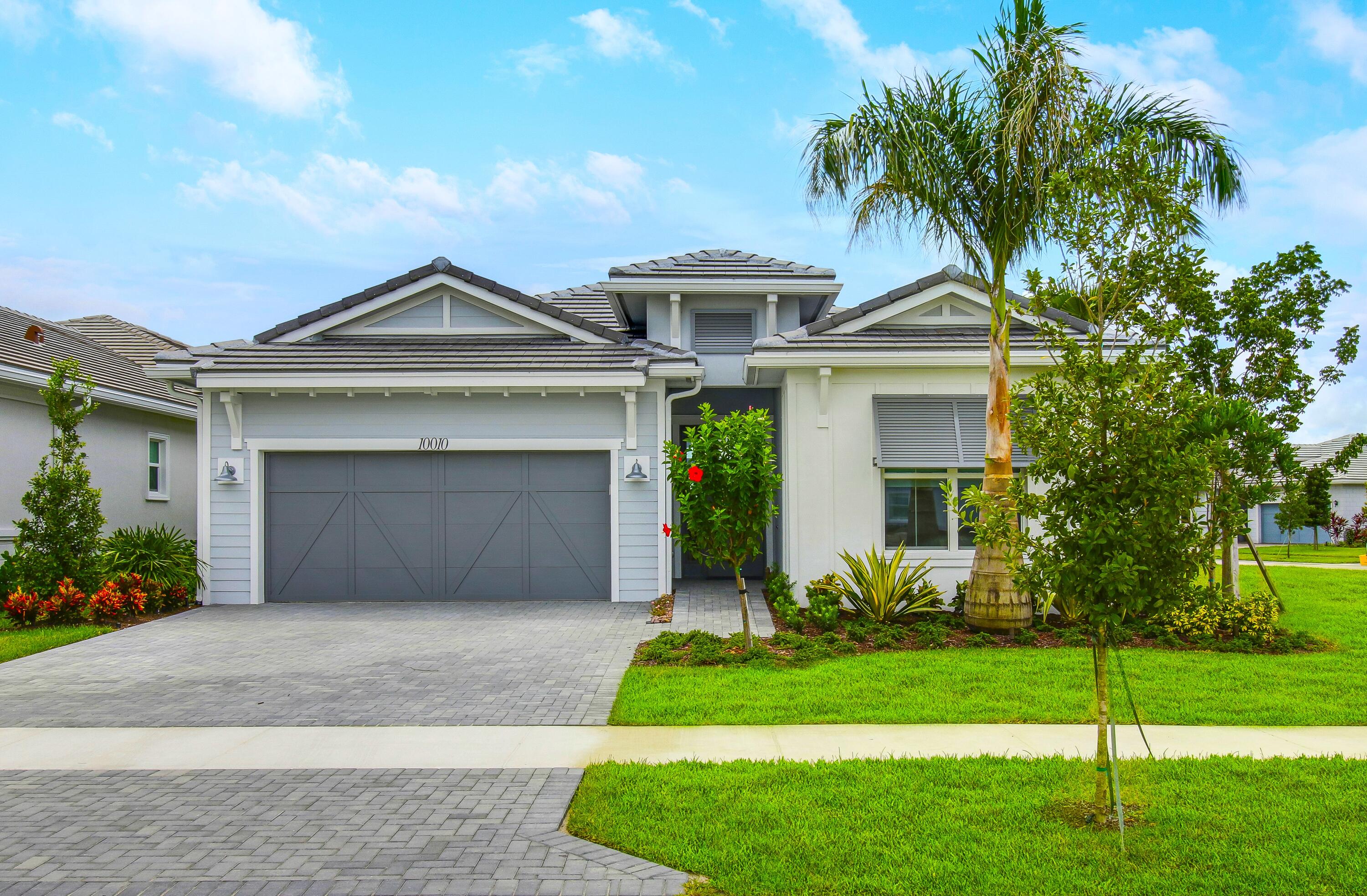 a front view of a house with a garden and garage