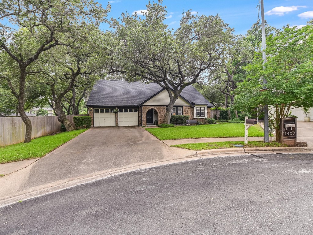 a view of a house with a big yard and large trees