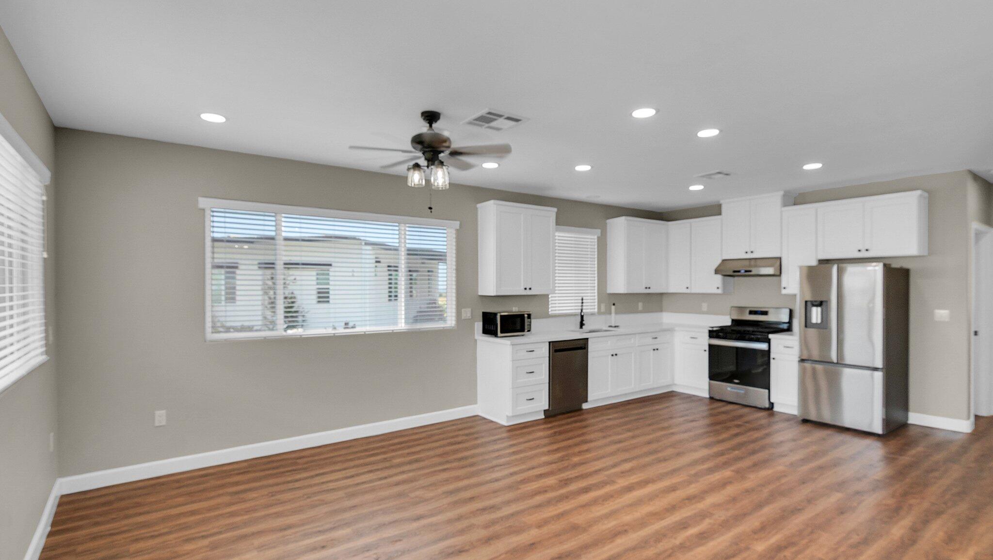 a large kitchen with stainless steel appliances granite countertop a stove and a refrigerator