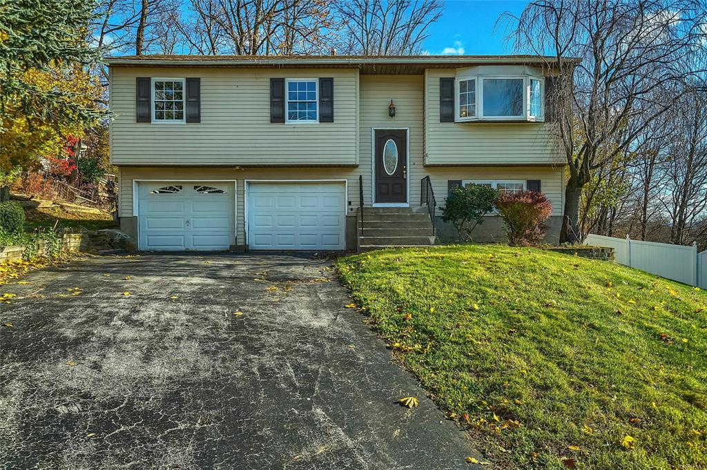 Split foyer home with a garage and a front yard