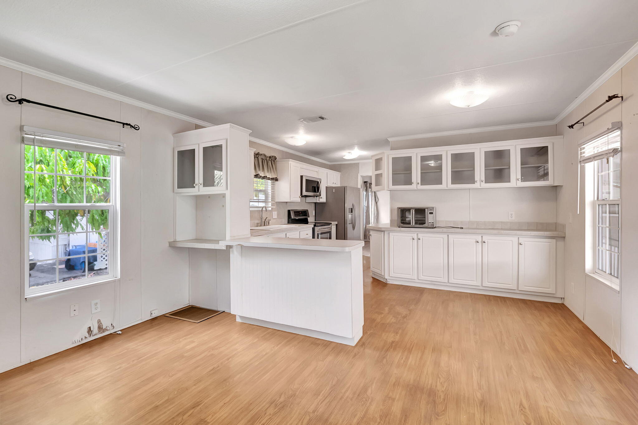 a view of kitchen with wooden floor and electronic appliances