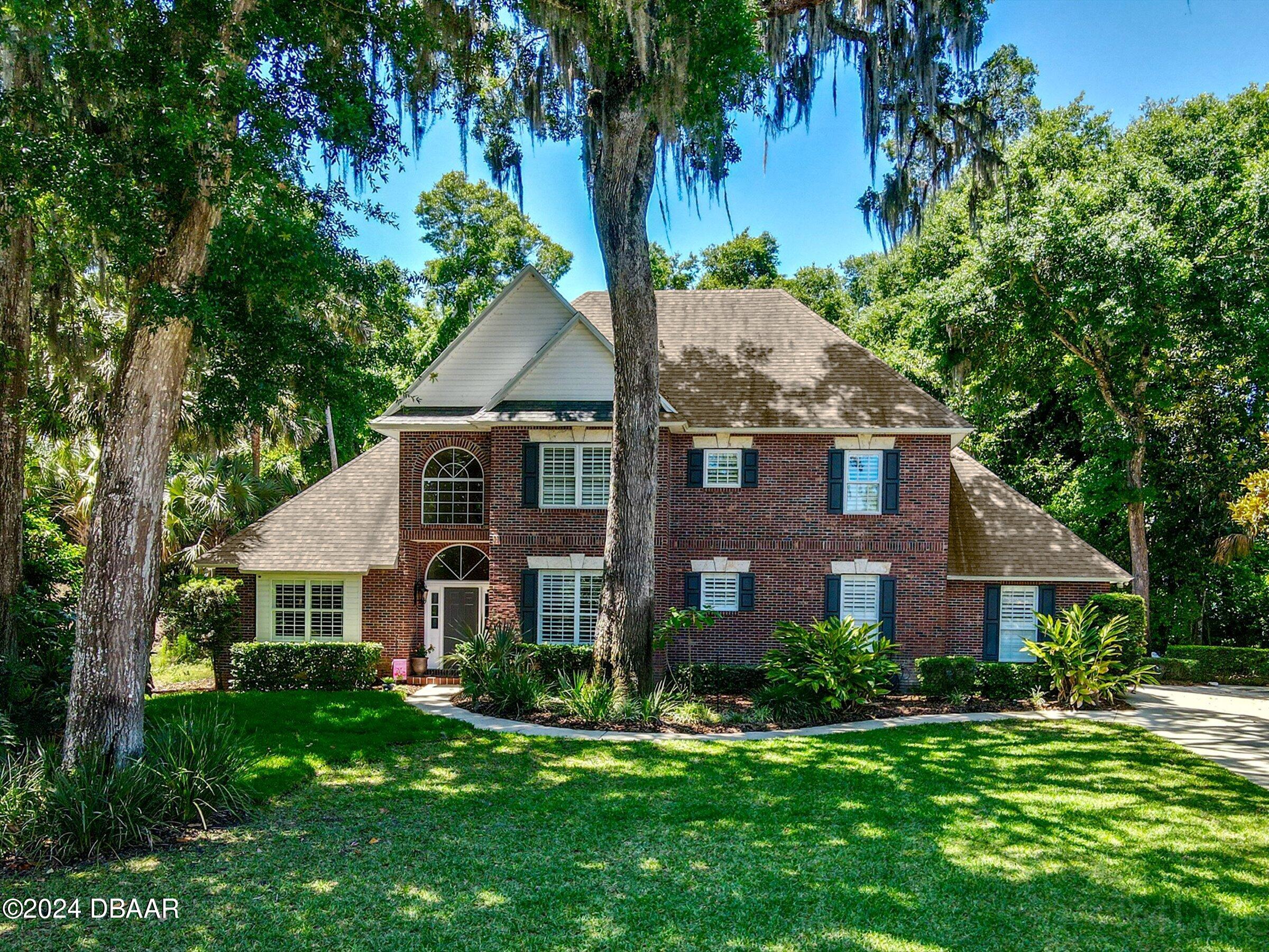 a front view of a house with a yard and trees