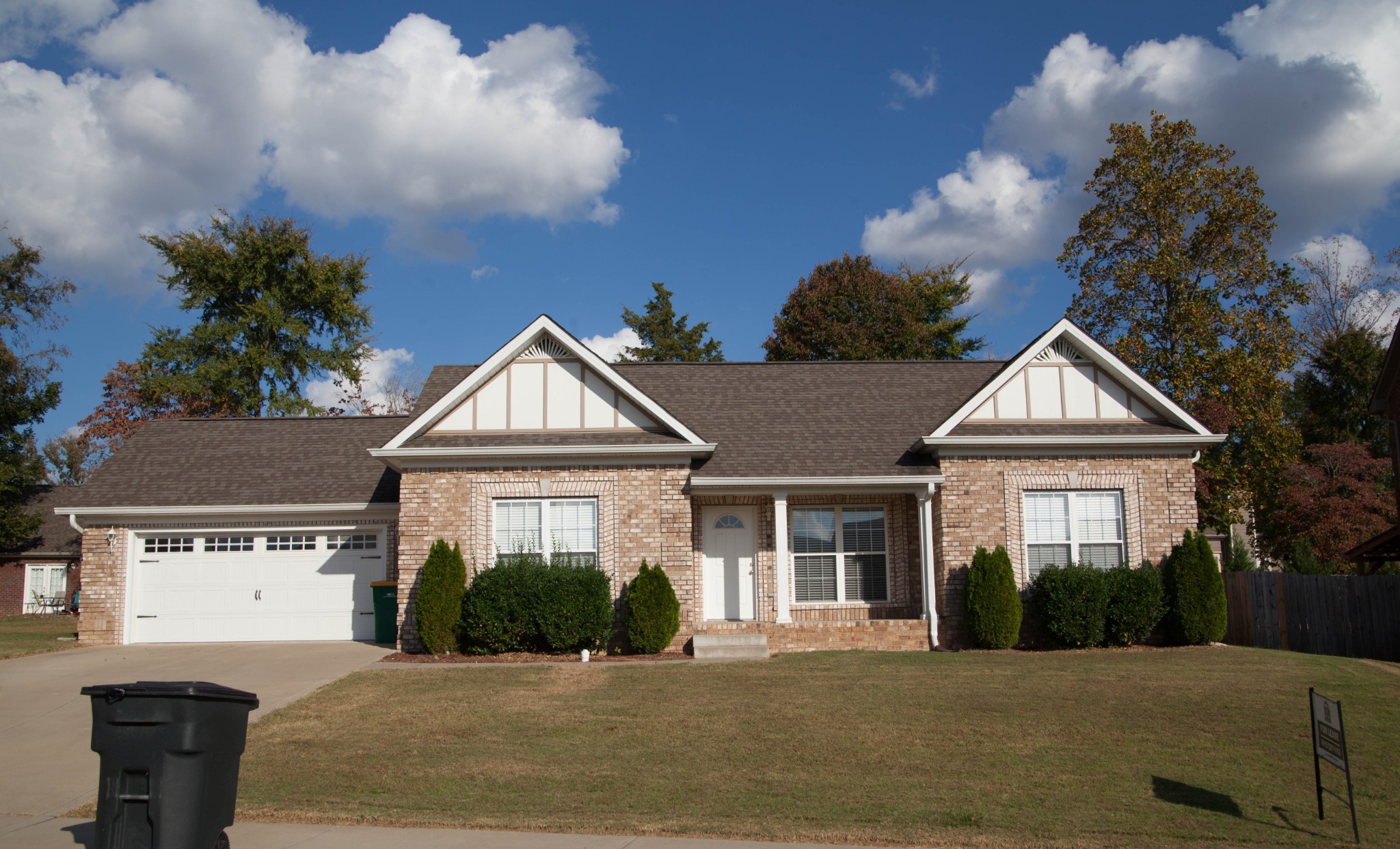 a front view of a house with a yard and potted plants