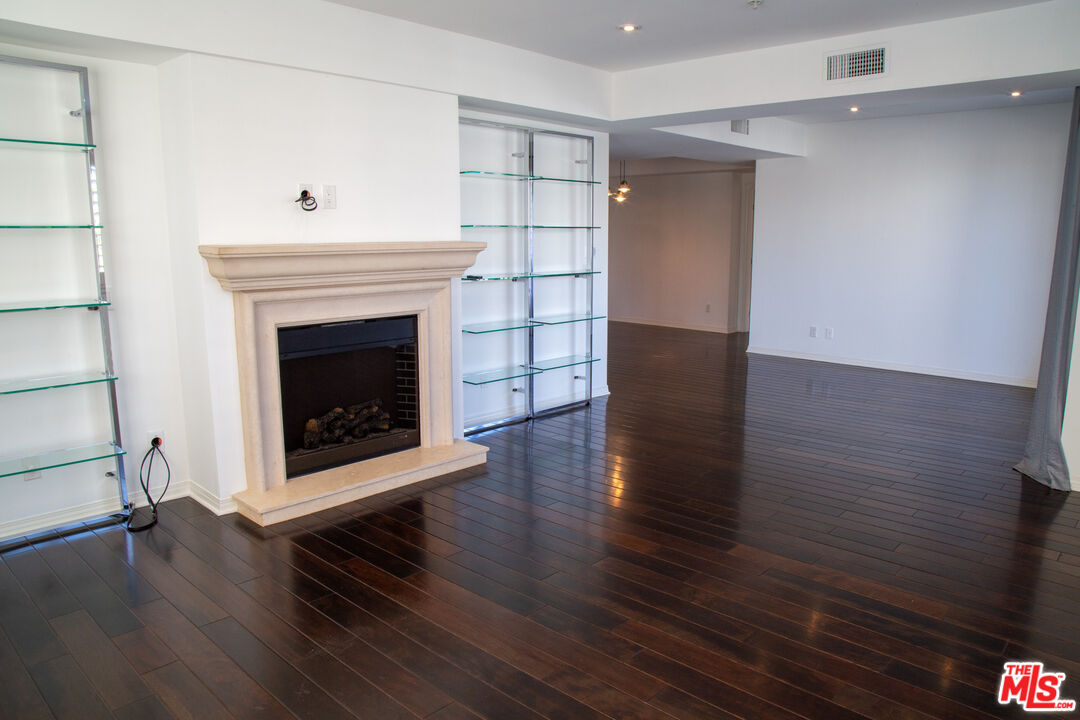 a view of a livingroom with wooden floor and a fireplace