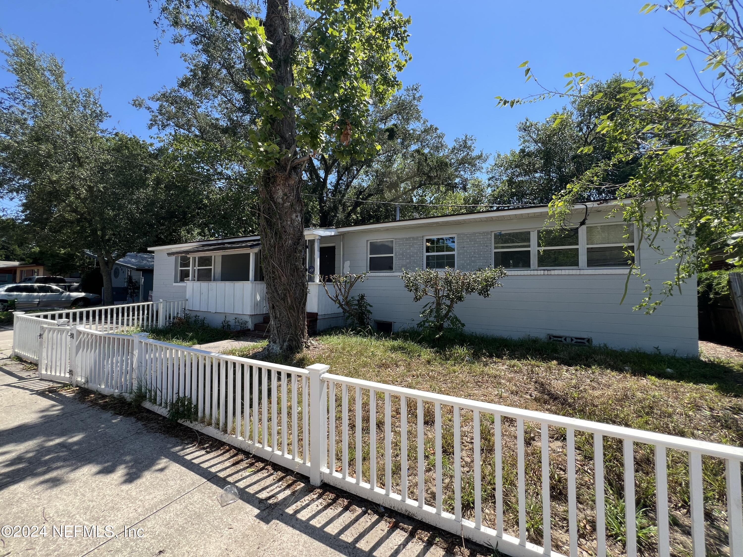 a front view of house with deck and backyard