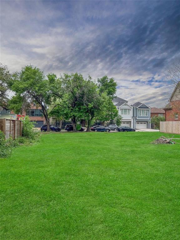 a view of a house with a big yard and large trees