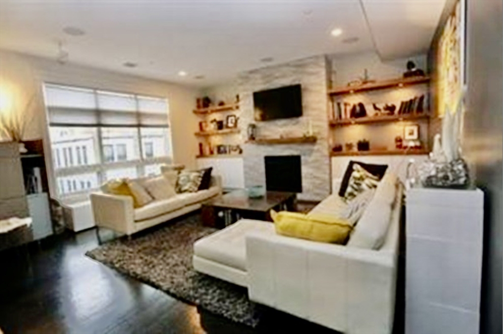 a living room with furniture wooden floor and a fireplace