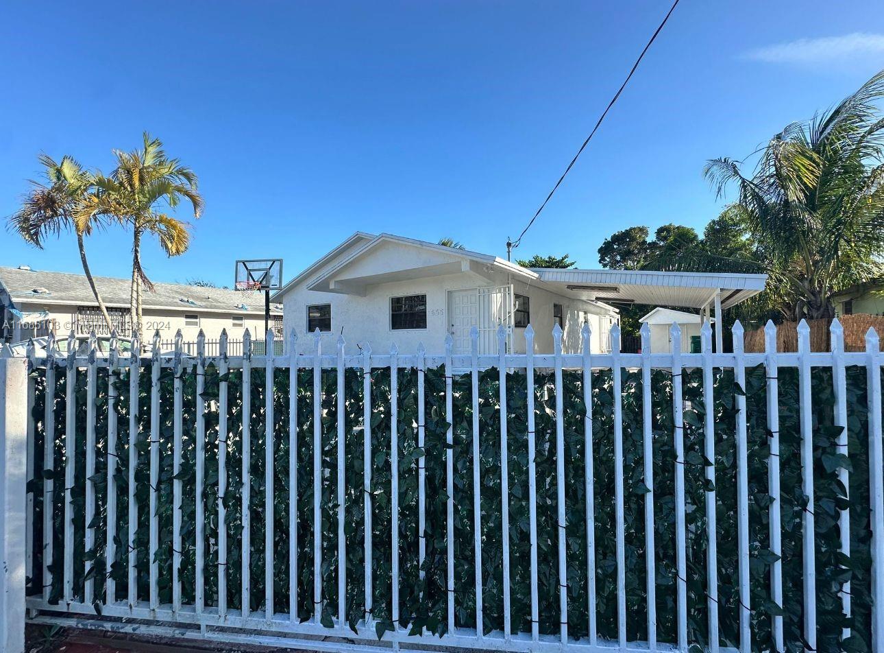 a view of a house with a wooden fence