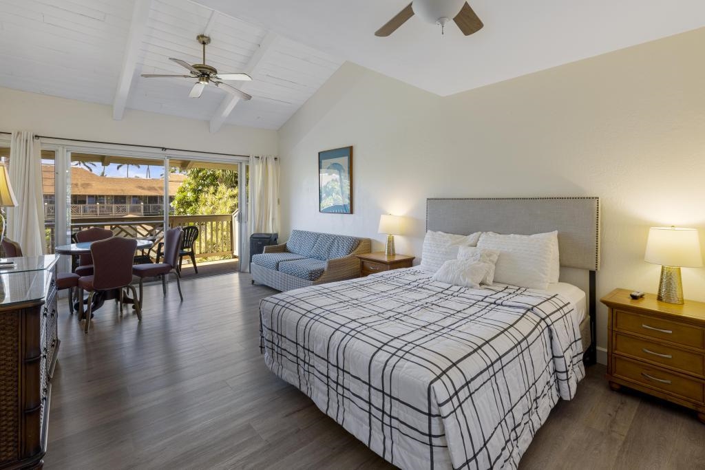 a bedroom with bed a chandelier and a large window