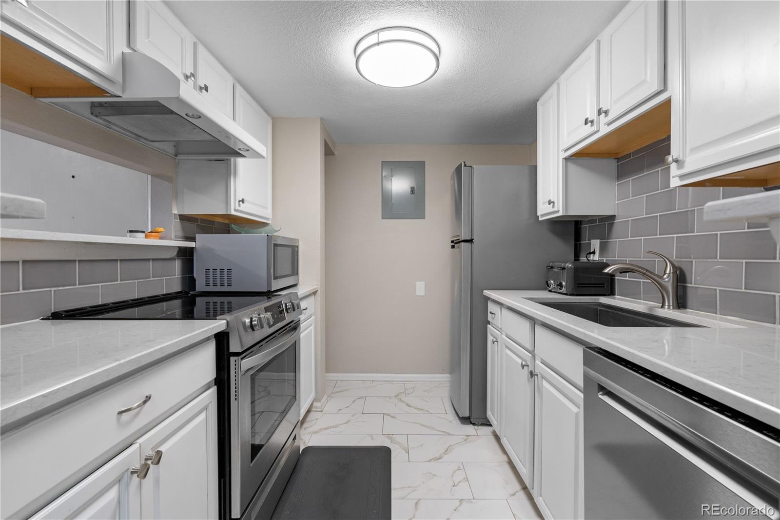 a kitchen with stainless steel appliances granite countertop a sink and a stove